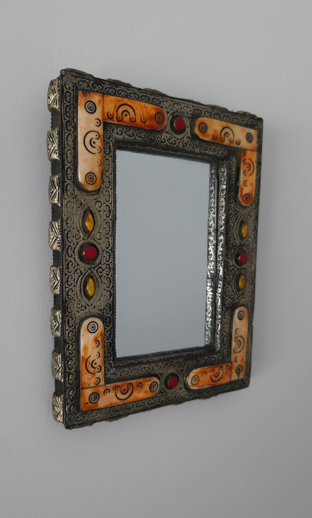 Decorative mirror with an ornate frame on a gray background