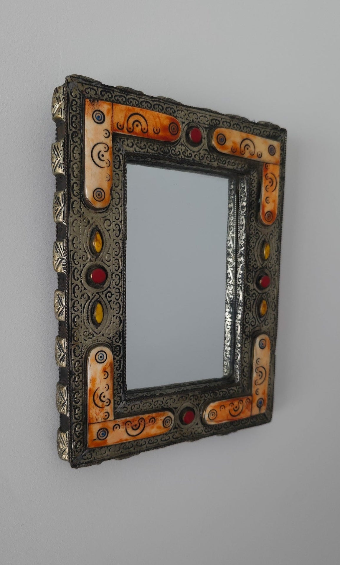 Decorative mirror with an ornate frame on a gray background