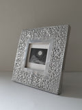 Decorative silver picture frame on a plain background